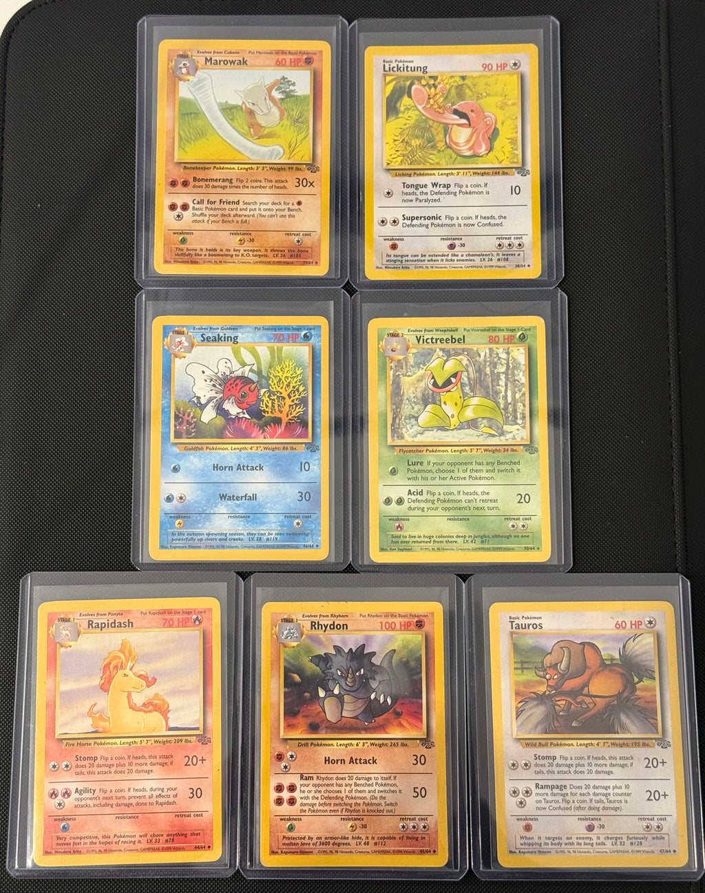 Actual english Pokémon cards — Marowak 39/64, Lickitung 38/64, Seaking 46/64, Victreebel 30/64, Rapidash 44/64, Rhydon 45/64, Tauros 47/64 — bundle photograph